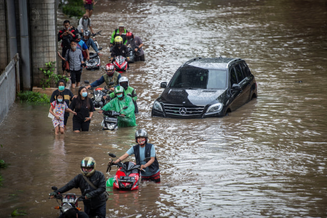 Warga mendorong sepeda motornya melintasi banjir di Jalan Kapten Tendean, Mampang Prapatan, Jakarta, Sabtu (20/2).  Foto: Aprillio Akbar/ANTARA FOTO