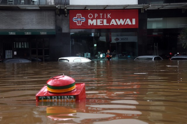 Warga berjalan melewati banjir di kawasan Kemang, Jakarta Selatan, Sabtu (20/2).  Foto: Indrianto Eko Suwarso/ANTARA FOTO