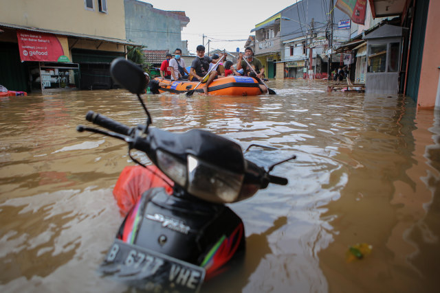 Petugas mengevakuasi warga menggunakan perahu karet saat banjir di Ciledug Indah, Kota Tangerang, Banten, Sabtu (20/2).  Foto: Fauzan/ANTARA FOTO