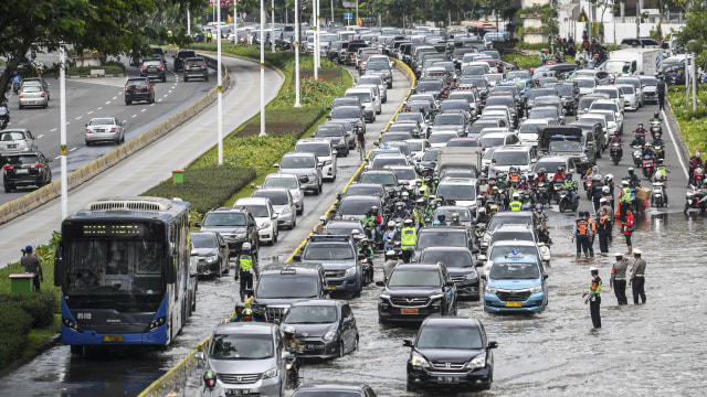 Sejumlah pengendara melintasi banjir di kawasan Jalan Jenderal Sudirman. Foto: ANTARA FOTO/M Risyal Hidayat