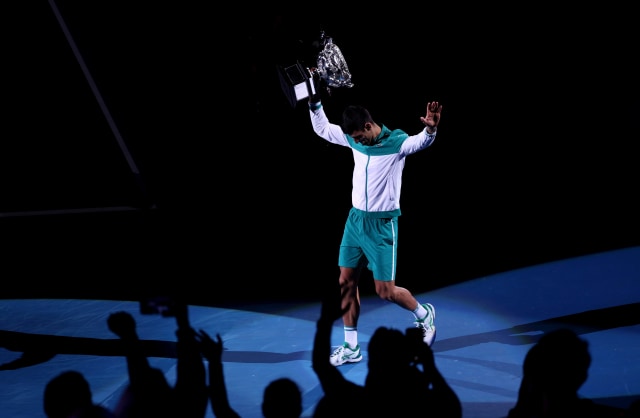 Novak Djokovic dari Serbia membawa trofi  Australian Open 2021 usai melawan petenis Rusia Daniil Medvedev. Foto: Loren Elliott/Reuters