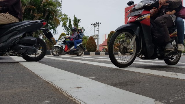 Warga melintas di pita penggaduh di Jalan Ahmad Yani Pontianak. Foto: Leo Prima/Hi!Pontianak