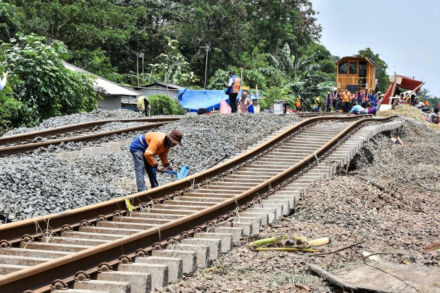 Petugas memperbaiki rel kereta api yang rusak akibat banjir di Kedungwaringin, Kabupaten Bekasi, Jawa Barat, Senin (22/2). Foto: Fakhri Hermansyah/Antara Foto