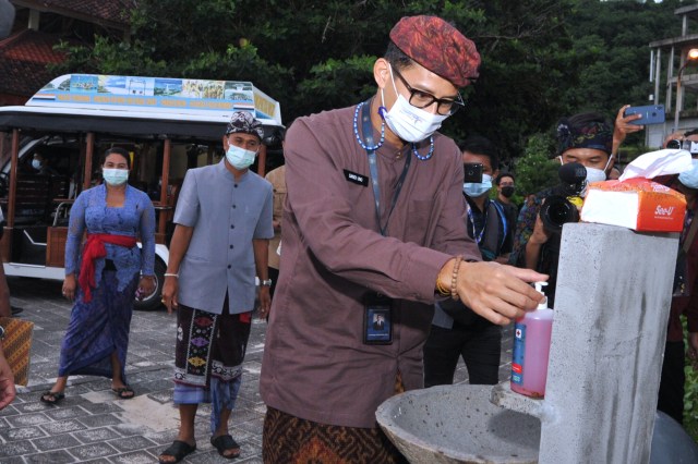 Menteri Pariwisata dan Ekonomi Kreatif Sandiaga Uno mencoba fasilitas protokol kesehatan berupa wastafel untuk mencuci tangan di Pantai Pandawa, Badung, Bali, Kamis (11/2/2021). Foto: Fikri Yusuf/ANTARA FOTO