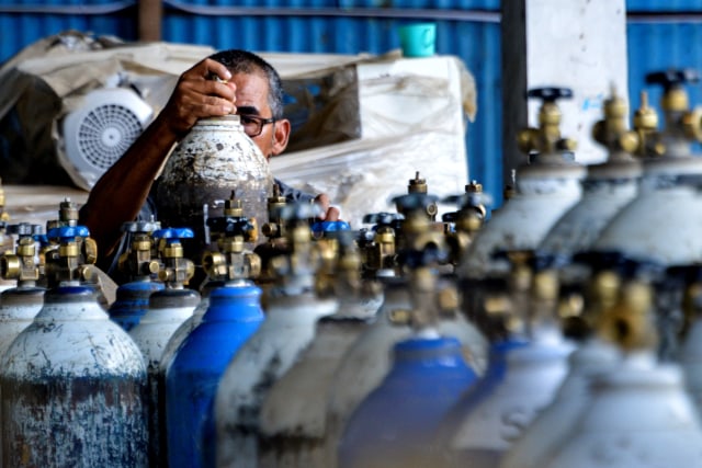 Pekerja mengecek tabung oksigen di depot pengisian di Banda Aceh, Aceh, Rabu (24/2). Foto: Chaideer Mahyuddin/AFP