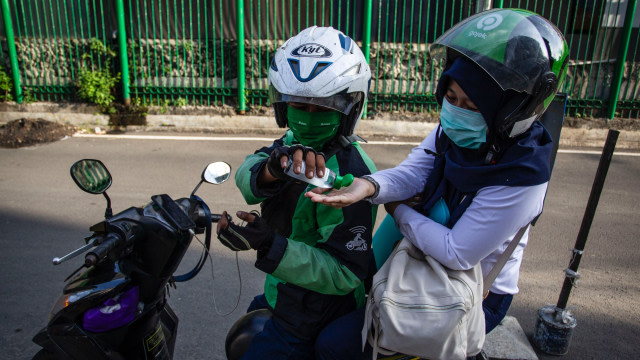 Pengemudi ojek online memberikan cairan hand sanitizer kepada penumpang di kawasan Jl. Kendal, Jakarta, Senin (8/6). Foto: Antara/Dhemas Reviyanto