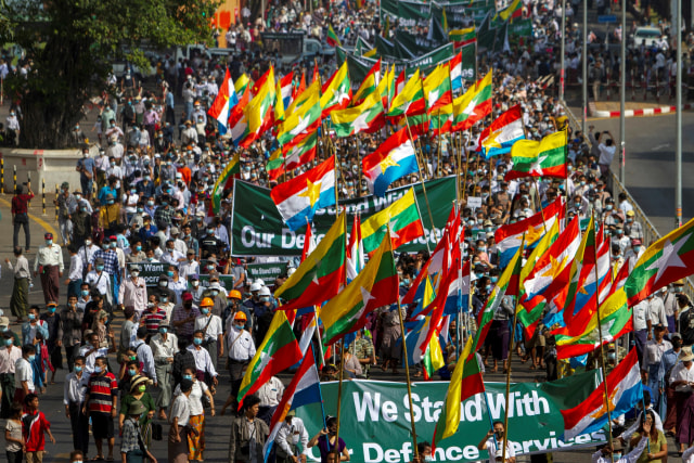 Pendukung militer Myanmar membawa spanduk dan bendera saat unjuk rasa di Yangon, Myanmar. Foto: STR/REUTERS