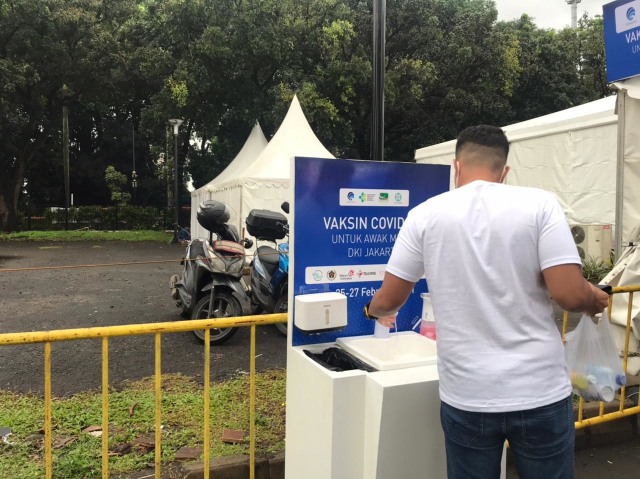 Peserta vaksin diwajibkan mencuci tangan sebelum memasuki Hall A GBK, Jumat (26/2). Foto: Karina/kumparan