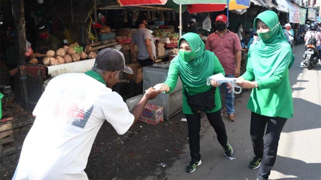 Ketua Persit Kartika Chandra Kirana Cabang XXXVI Kodim Bondowoso membagikan Masker pada warga di Pasar Induk Bondowoso.(dok).