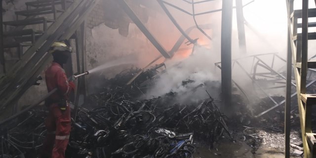 Petugas pemadam kebakaran berupaya memadamkan api yang menghanguskan pabrik sepeda di Batam, Foto: Rega/kepripedia.com