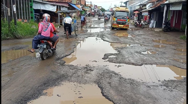 Di jalan raya Pabuaran, Kecamatan Pabuaran, Kabupaten Cirebon, tepatnya di depan pasar sayur, kondisi lubang-lubang menganga banyak terlihat di sepanjang jalan. (Tomi Indra)