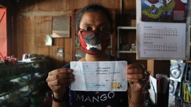 Kusmiyati, seorang ibu di Grobogan Jawa Tengah memegang kwitansi pembayaran 'uang pelicin' agar anakya masuk jadi PNS. Foto: kumparan
