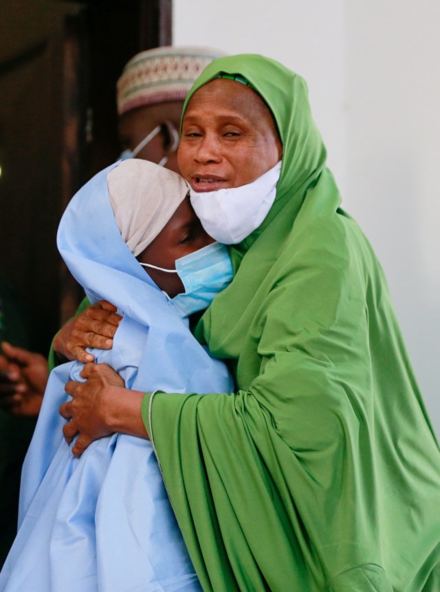 Seorang pejabat memeluk seorang gadis yang diculik dari sebuah sekolah asrama, setelah dibebaskan di Zamfara, Nigeria, Selasa (2/3). Foto: Afolabi Sotunde/REUTERS