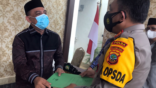 Ketua PW GP Ansor Sulut, Yusra Alhabsyi menyerahkan bukti capture penghinaan terhadap Ketua PBNU dan Menteri Agama di Sosmed kepada Kapolda Sulawesi Utara. (foto: dokumen istimewa)
