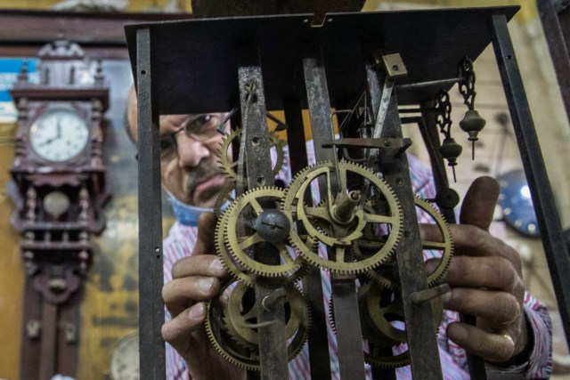 Karam Iskandar, seorang pembuat jam Mesir berusia 56 tahun, memperbaiki jam di toko pembuat jam tangan Francis Papazian di Attaba, Kairo, Mesir. Foto: Khaled Desouki/AFP
