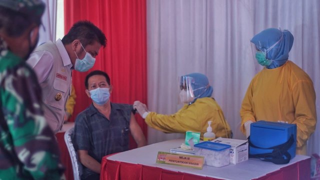 Penyuntikan vaksin corona kepada pedagang Pasar Cinde Palembang. (foto: Ary Priyanto/Urban Id)