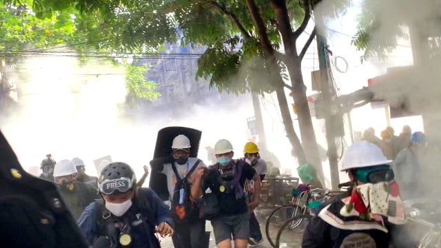 Para pengunjuk rasa meledakkan granat asap untuk menghalangi pandangan dari penembak jitu di Sanchaung, Yangon, Myanmar, Rabu (3/3). Foto: Reuters