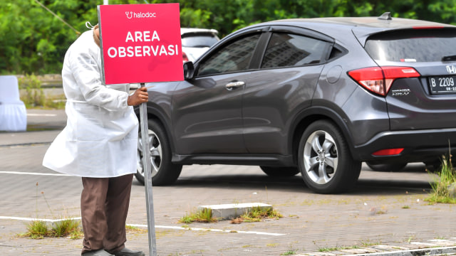 Petugas kesehatan memasang tanda jalan di lokasi vaksin COVID-19 Sinovac secara drive thru untuk lansia di kawasan Kemayoran, Jakarta, Rabu (3/3/2021). Foto: Muhammad Adimaja/ANTARA FOTO
