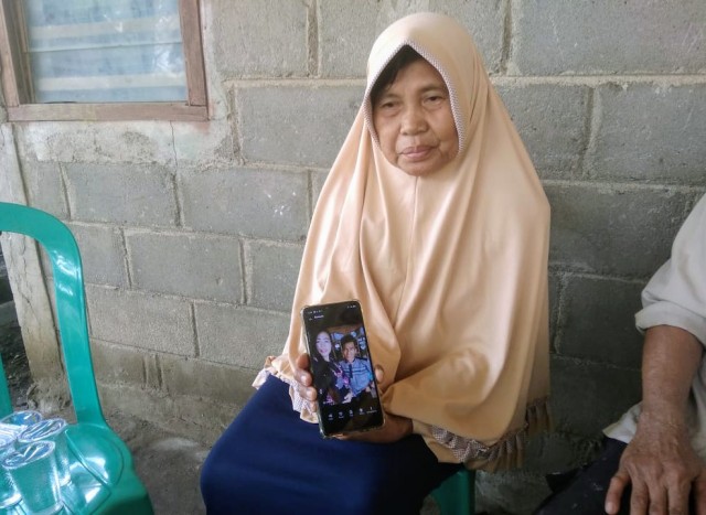 Sang nenek saat memperlihatkan foto korban yang tewas dibacok mantan suaminya. (foto: istimewa)