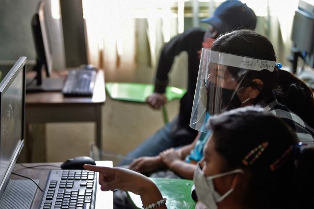 Norma Arely Hernandez (tengah) menghadiri kelas ilmu komputer di lingkungan Escalerillas di Chimalhuacan, negara bagian Meksiko. Foto: ALFREDO ESTRELLA / AFP
