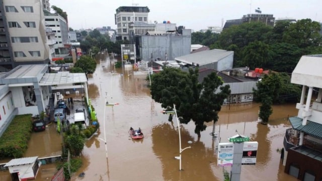 Ilustrasi dari udara yang menunjukkan sekelompok orang sedang menelusuri jalanan yang tergenang banjir menggunakan perahu karet di Jakarta 20-2-2021. Foto AFP