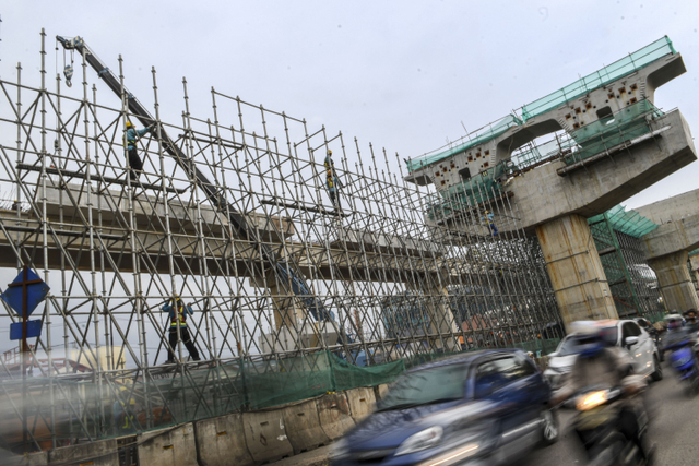 Pekerja menyelesaikan proyek pembangunan ruas jalan tol. Foto: ANTARA FOTO/M Risyal Hidayat