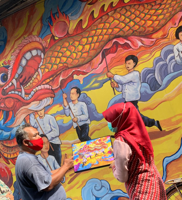 Penggagas Kampung Pecinan menunjukkan konsep mural yang digambar di dinding Gang Gajahmadah 9 kepada Kadisporapar Kalbar. Dok: Teri/Hi!Pontianak