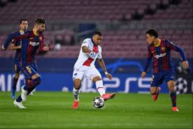 Kylian  Mbappe (Jersey putih) sedang berusaha mengkontrol bola, dikawal oleh Sergio Dest (Jersey Merah) dan Gerard Pique (Jersey Merah) Source: Getty Images