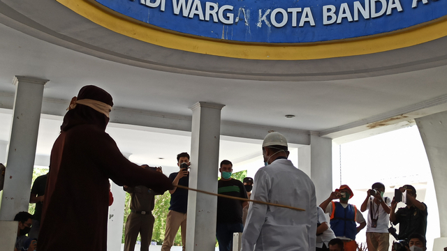 Oknum PNS pelaku jarimah Ikhtilat menjalani hukuman cambuk di Taman Bustanusslatin, Kota Banda Aceh, Senin (8/3). Foto: Husaini Ende/acehkini