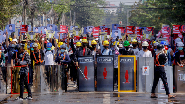 Pengunjuk rasa anti-kudeta berdiri di belakang barisan perisai darurat saat berdemonstrasi di Yangon, Myanmar, Selasa (9/3). Foto: AP Photo