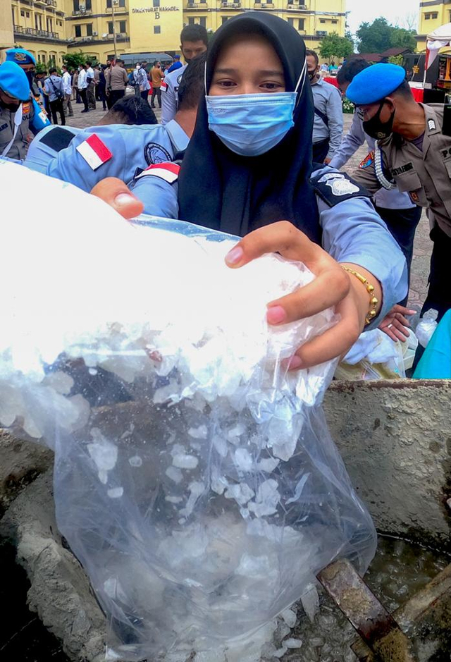 Personel Polda Aceh memasukkan barang bukti narkotika jenis sabu-sabu ke mesin molen untuk dimusnahkan, Rabu (10/3/2021). Foto: Suparta/acehkini