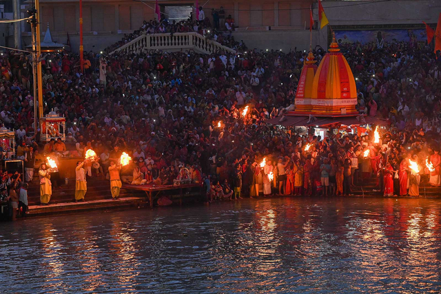 Umat Hindu menghadiri ritual petang setelah berendam di air Sungai Gangga pada kesempatan festival Maha Shivratri selama festival keagamaan Kumbh Mela di Haridwar (11/3). Foto: PRAKASH SINGH/AFP