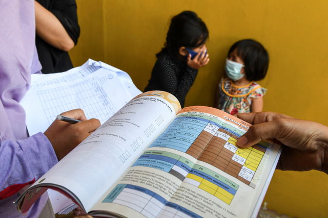 Kader posyandu mencatat jadwal imunisasi di Rorotan, Jakarta Utara. Foto: M Risyal Hidayat/ANTARA FOTO