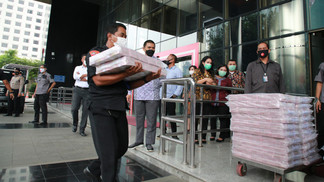 Petugas membawa uang sitaan kasus korupsi ekspor benur di Gedung KPK, Jakarta, Senin (15/3).  Foto: Humas KPK