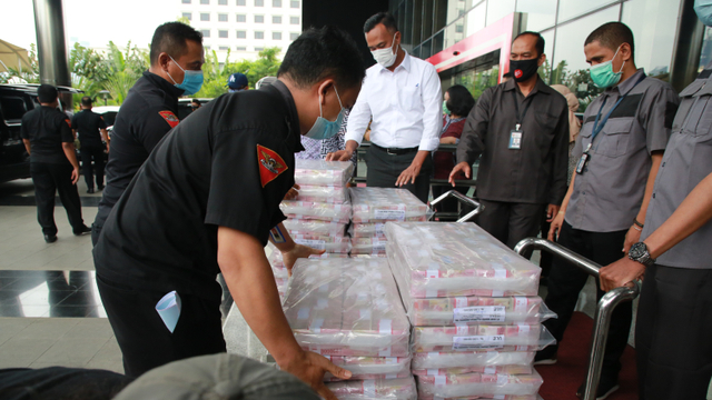 Petugas menyusun uang sitaan kasus korupsi ekspor benur di Gedung KPK, Jakarta, Senin (15/3).  Foto: Humas KPK