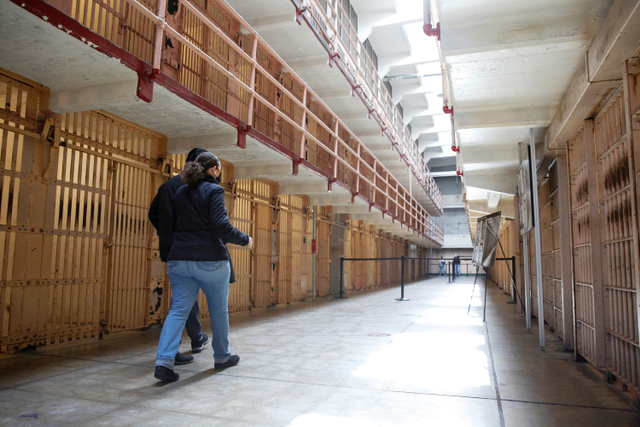 Pengunjung mendengarkan tur audio mandiri di rumah sel utama saat Pulau Alcatraz dan bekas penjara dibuka kembali di Teluk San Francisco, California, AS. Foto: Brittany Hosea-Small/REUTERS