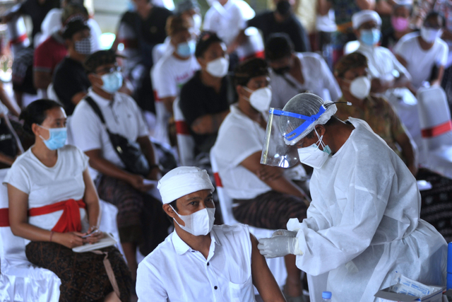 Petugas kesehatan menyuntikkan vaksin COVID-19 kepada masyarakat di kawasan Ubud, Gianyar, Bali, Selasa (16/3). Foto: Fikri Yusuf/ANTARA FOTO