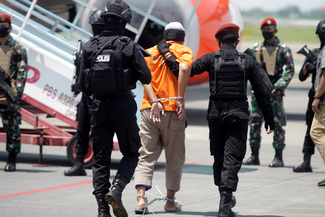 Personel Densus 88 Anti Teror membawa terduga teroris menuju ke pesawat udara di Bandara Internasional Juanda, Sidoarjo, Jawa Timur, Kamis (18/3/2021). Foto: Umarul Faruq/ANTARA FOTO