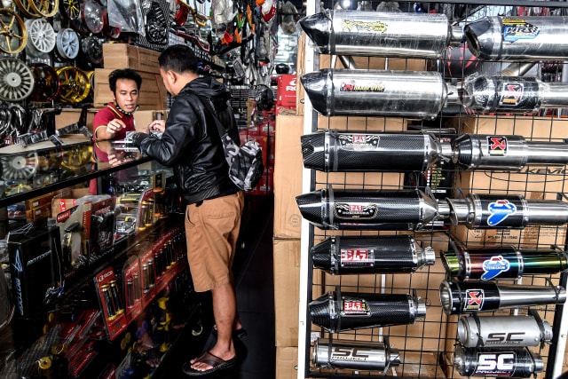 Penjual knalpot dan aksesori modifikasi sepeda motor melayani calon pembeli di kawasan Kampung Melayu, Jakarta. Foto: Muhammad Adimaja/Antara Foto