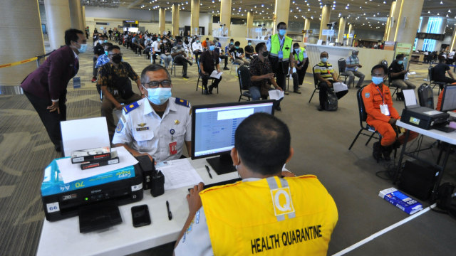 Petugas memeriksa data petugas bandara yang akan menjalani vaksinasi corona di kawasan Terminal Internasional Bandara Internasional I Gusti Ngurah Rai, Badung, Bali, Senin (22/3). Foto: Fikri Yusuf/ANTARA FOTO
