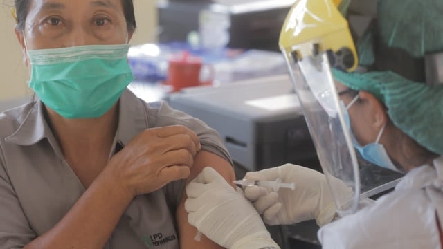 Vaksinator menyuntikkan vaksin COVID-19 kepada warga saat vaksinasi massal di Denpasar, Bali.  Foto: Dok. Istimewa