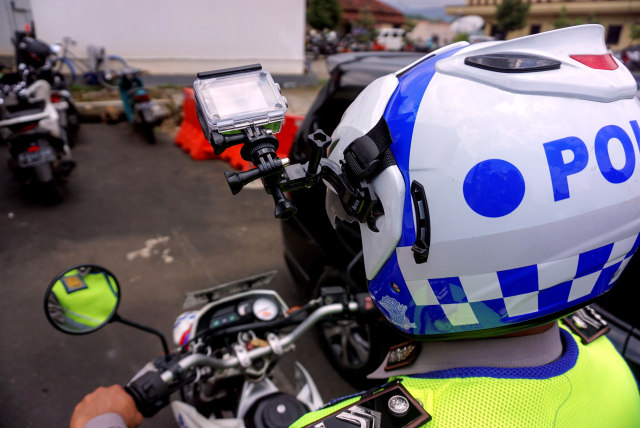 Polisi Lalu Lintas menggunakan helm yang dilengkapi kamera portabel pengawas tilang elektronik di TMC Polres Pekalongan, Jawa Tengah, Selasa (23/3). Foto: Harviyan Perdana Putra/Antara Foto