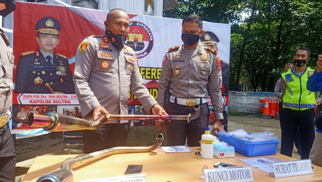 Kapolres Kendari, AKBP Didik Erfianto saat menunjukkan knalpot bising yang berhasil disita dari pemiliknya. Foto: Deden Saputra/kendarinesia.
