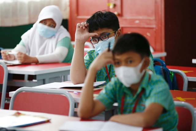 Sejumlah siswa mengenakan masker dan menrapkan jaga jarak soial (social distancing) mengikuti kegiatan sekolah tatap muka di Bekasi, Rabu (24/3).  Foto: Willy Kurniawan/REUTERS