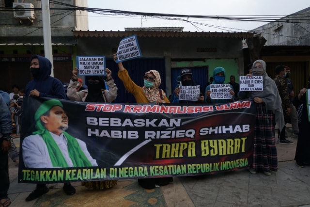 Simpatisan Habib Rizieq Syihab membentangkan spanduk dan poster di sekitar PN Jaktim. Foto: Jamal Ramadhan/kumparan