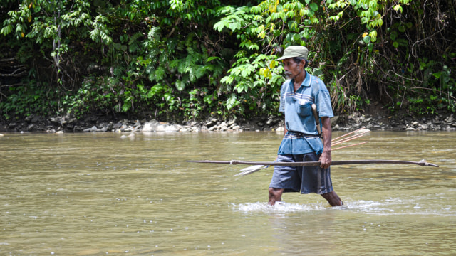 Antonius, salah satu Suku Tobelo Komunitas Togutil saat menelusuri sungai untuk berburu di Hutan Ake Tajawe Lolobata, Halmahera, Maluku Utara. Foto: Faris Bobero/cermat 