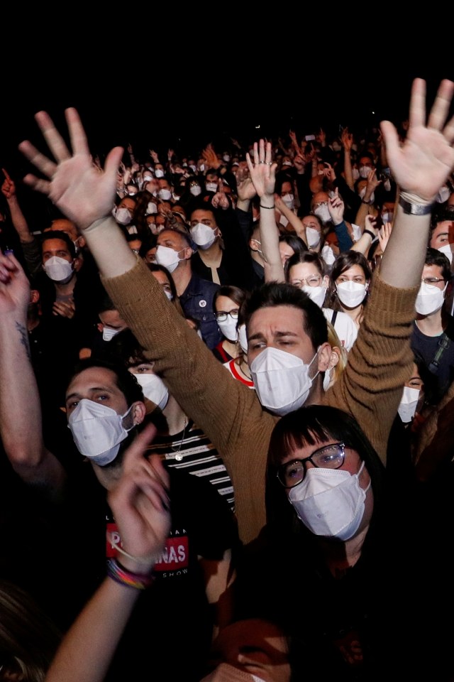 Orang-orang mengenakan masker saat menonton konser musik di Palau Sant Jordi di Barcelona, Spanyol, Sabtu (27/3). Foto: Albert Gea/REUTERS