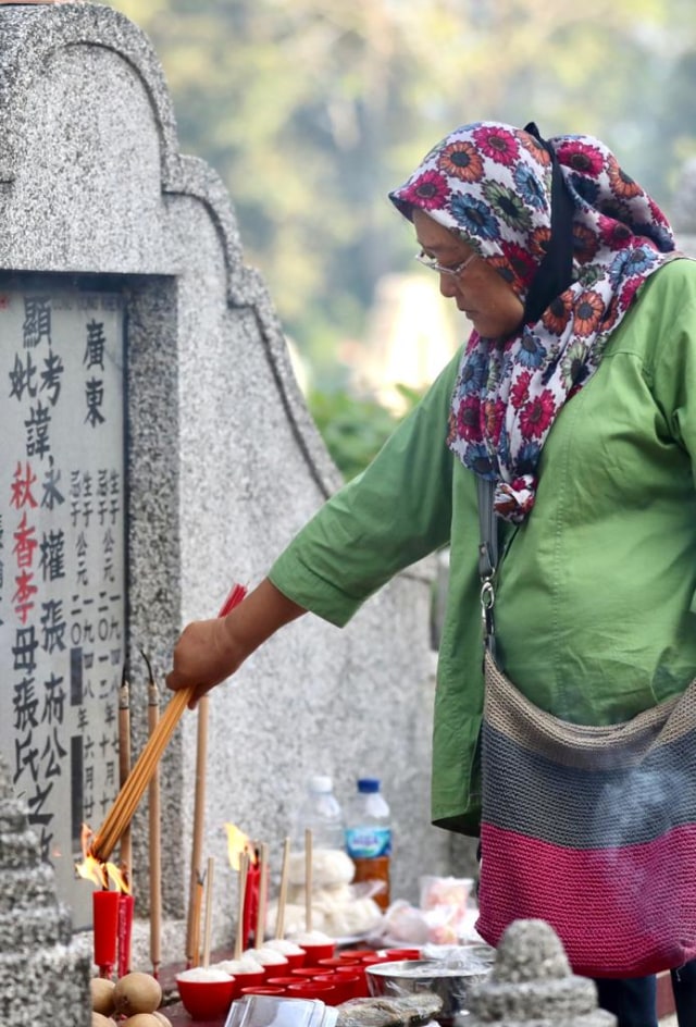 Tradisi Cheng Beng di Kompleks Pemakaman Tionghoa Mata Ie, Aceh Besar, Minggu (28/3/2021), berdoa di makam leluhur. Foto: Suparta/acehkini