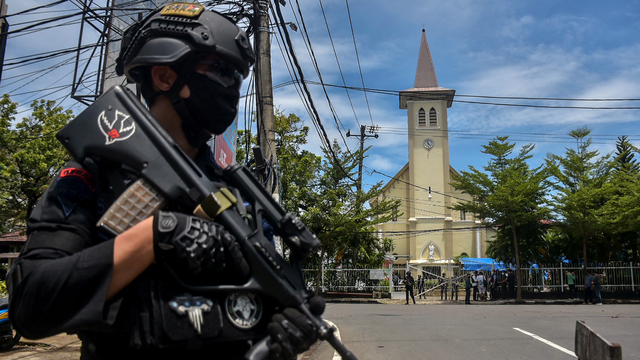 Petugas kepolisian berjaga di lokasi bom bunuh diri di depan Gereja Katolik Katedral, Makassar, Sulawesi Selatan, Minggu (28/3). Foto: INDRA ABRIYANTO/AFP