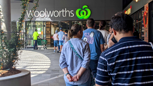 Pembeli mengantre di luar toko Woolworths, saat pemberlakuan lockdown, di Brisbane, Australia, Senin (29/3). Foto: AAP Image/Nick Gibbs via REUTERS